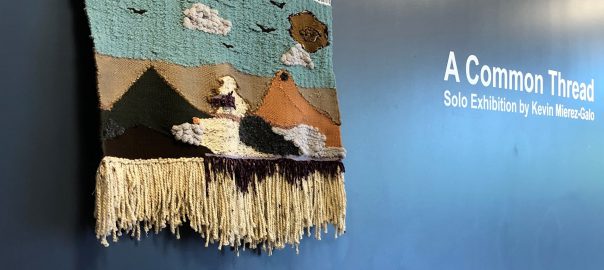 a woven tapestry hangs beside the words, a common space