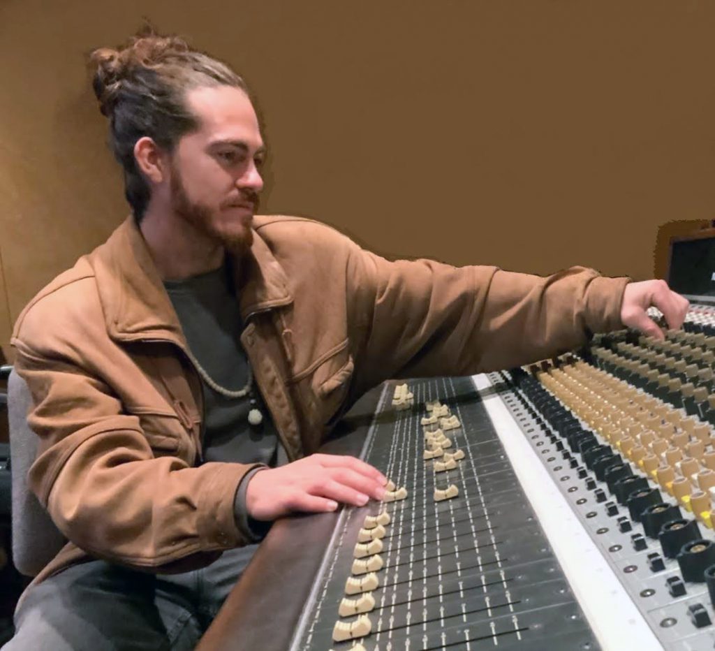 Skyler Golden, in leather jacket in front of mixing board