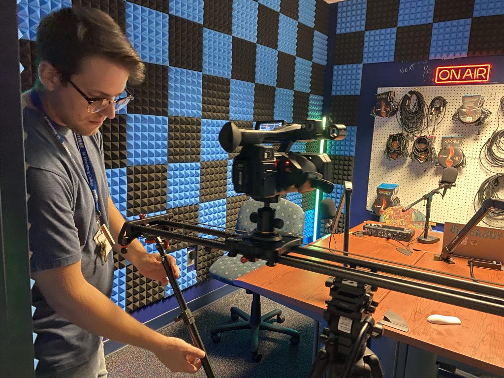 Jacob Lewis sets up a shot for a video recording session in the audio booth.