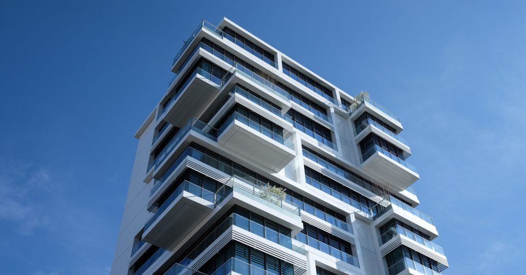 Commercial real estate skyscraper under a clear blue sky.