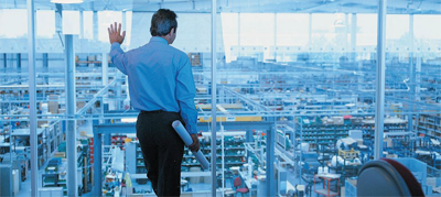 Supply Chain Management training. Man standing in front of construction.