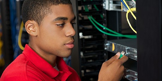 Photo of man plugging network cable into a switch
