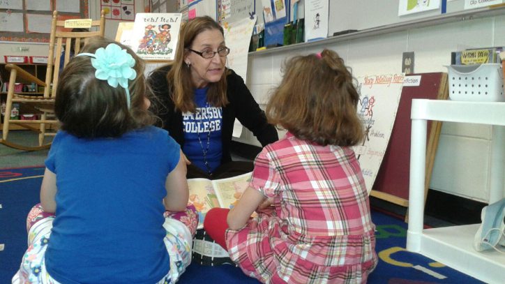 Photo of woman being read to by school children