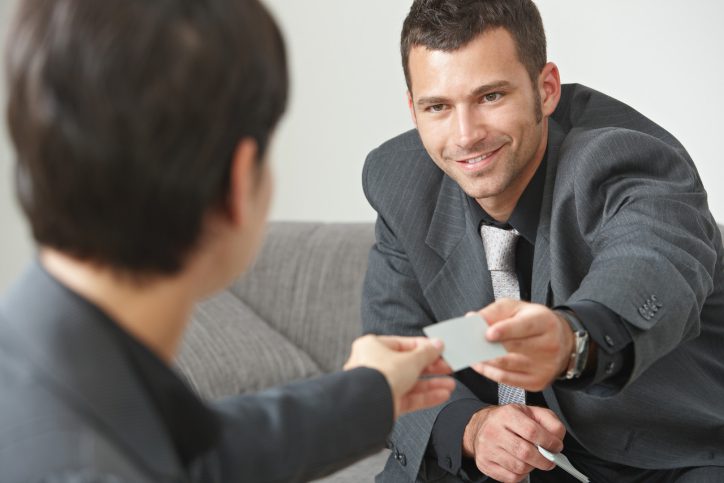 Two people exchanging business cards; soft skills