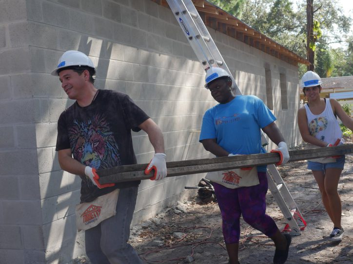 volunteers helping carry wood
