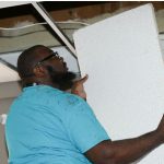 man replacing ceiling tile