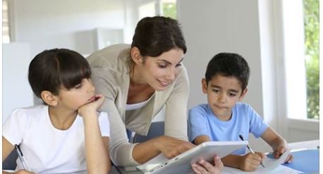 stock photo of teacher showing kids something on tablet