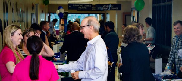 Free Business Workshops are being held at St. Pete/Gibbs Campus for students and community members. Photo is of a group of students, faculty, and community members gathering for business networking.
