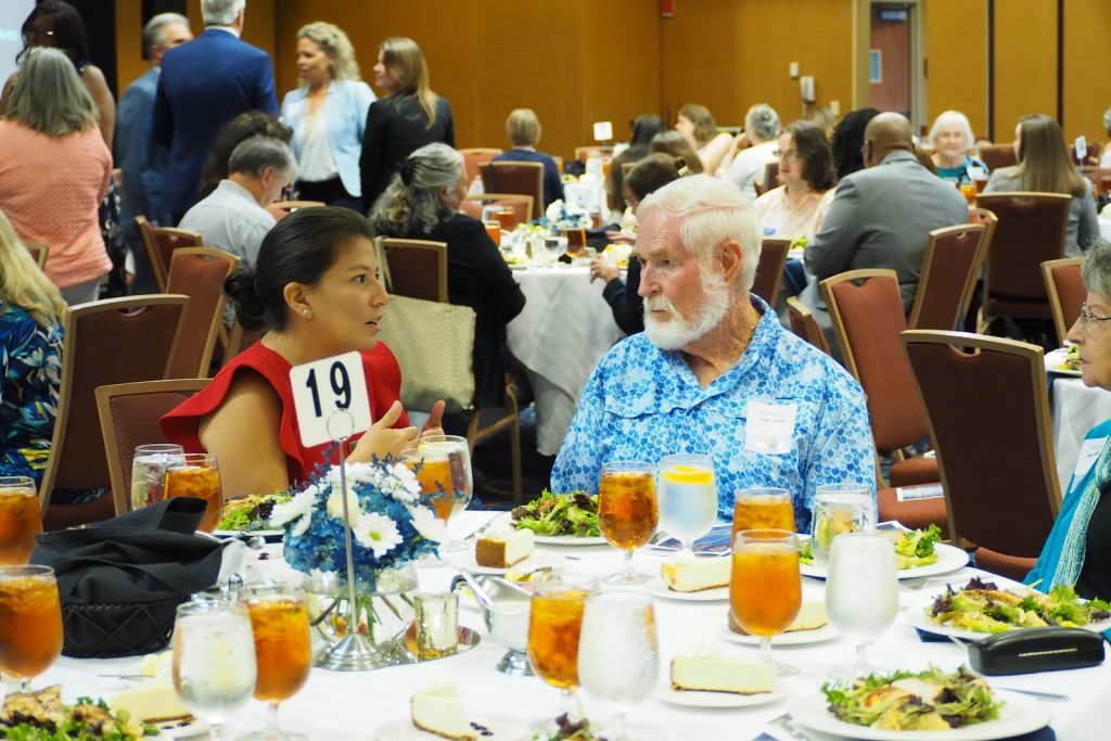 A woman and man have a discussion at a table set for lunch