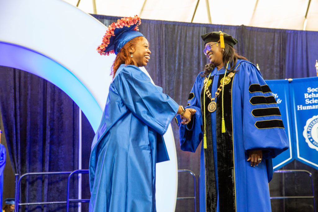 Dr. Williams shakes the hand of a graduate.