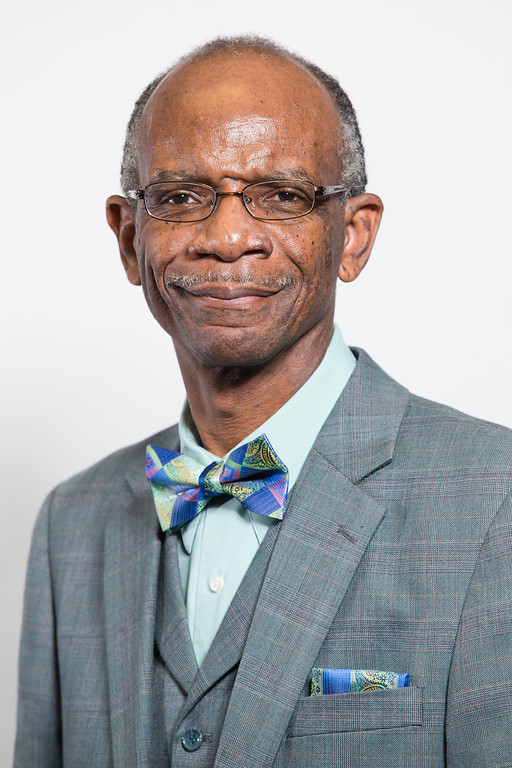 Dr. Smiley, wearing a grey suit and colorful bowtie