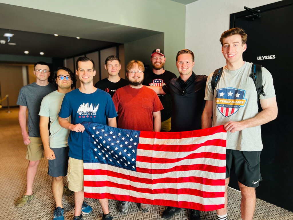 Monahan poses with the American team behind an American flag