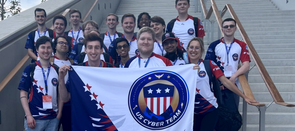 Monahan poses with the entire group of USA team members, who hold a USA Team flag in front